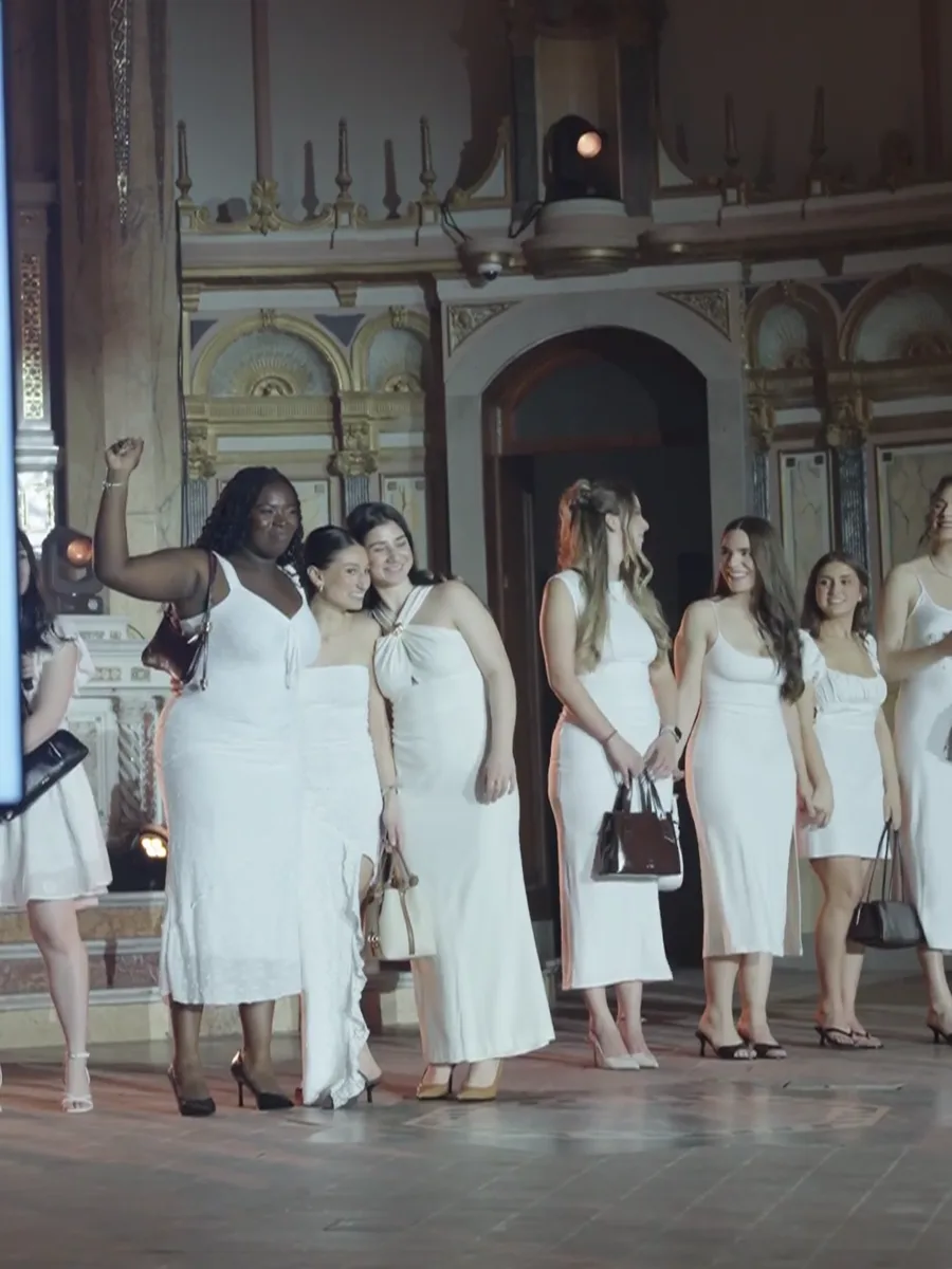 Guests in white dresses gathered under the arches at the GAIA fashion show