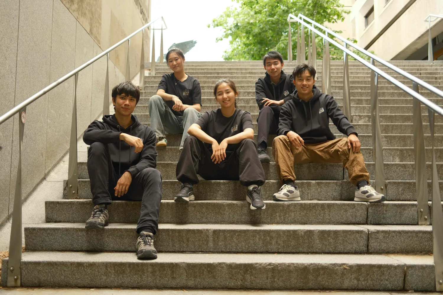 The OtterS crew sitting together on a set of steps in Montreal